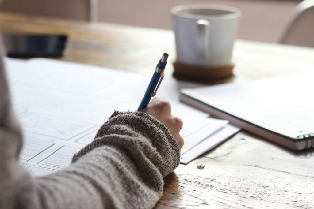 woman writing with pen on paper